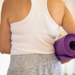 Perempuan bersiap olahraga di rumah dengan yoga mat